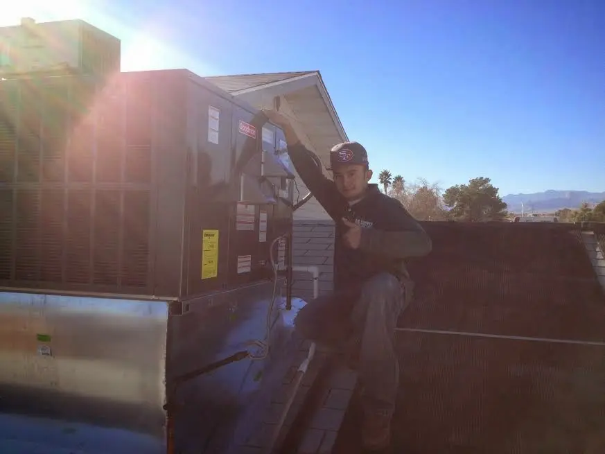 HVAC technician performing HVAC Inspection on a rooftop unit in Gardiner